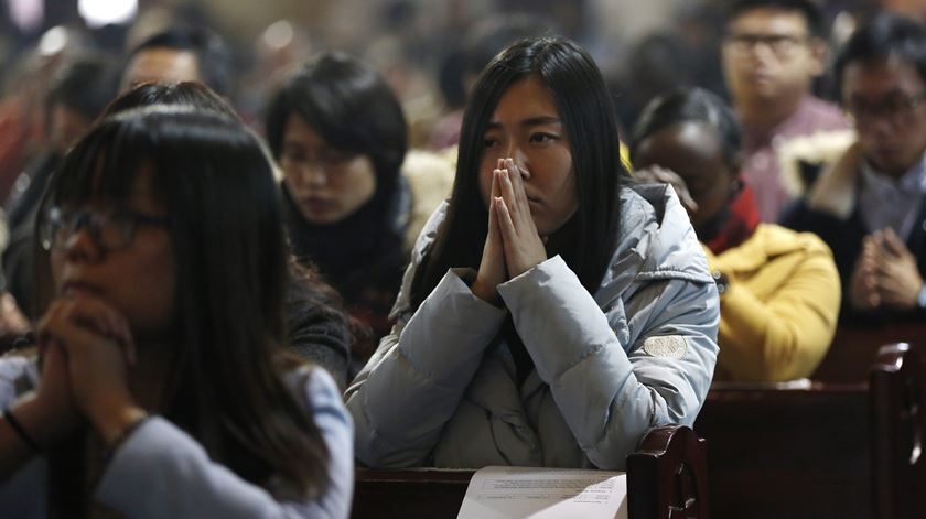 Católicos rezam numa igreja na China. Foto: EPA