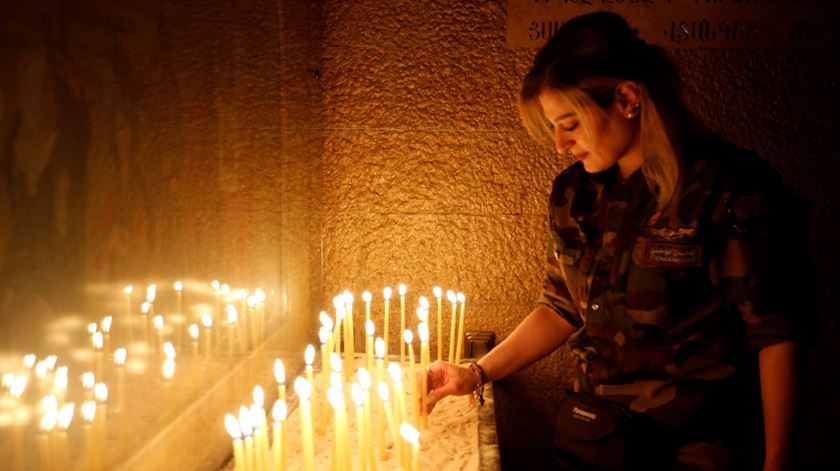 Uma miliciana cristã acende uma vela numa igreja libertada nos arredores de Mossul. Foto: Youssef Badawi/EPA